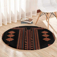 Round rug with black background and red diamond motifs along vertical bands
