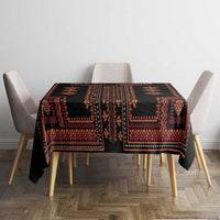 Square black tablecloth with red-orange geometric folk pattern across the top