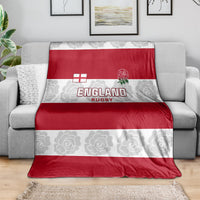 Red and white England Rugby blanket draped over a gray sofa
