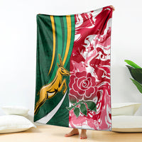 Rugby-themed blanket with green and red panels, yellow animal, and white floral designs