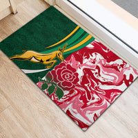 Green and red doormat rug with gold kangaroo emblem and white rose graphic