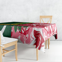 Tablecloth draped on table with bold green and red swirl pattern and white accents
