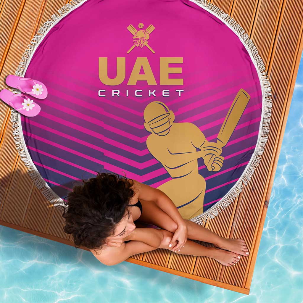 Pink round cricket beach blanket showing UAE Cricket text, batter graphic, and white fringe edge