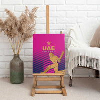 Pink cricket canvas wall art on easel with UAE Cricket logo and batsman