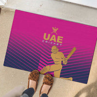 Pink UAE Cricket rubber doormat with gold batter figure and UAE Cricket logo, striped pattern