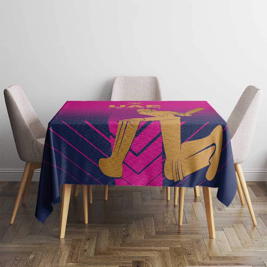 Pink UAE cricket tablecloth on table with gold batsman artwork and purple stripe lines