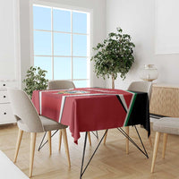 Red Kuwait Cricket tablecloth draped on round table with black, white, green stripe trim