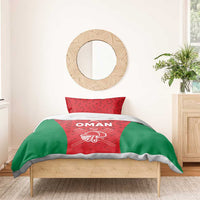 Red and green cricket bedding set with white “OMAN” text on the duvet and matching pillow
