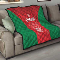 Oman cricket quilt draped on a sofa, red center with green sides and white “OMAN” text