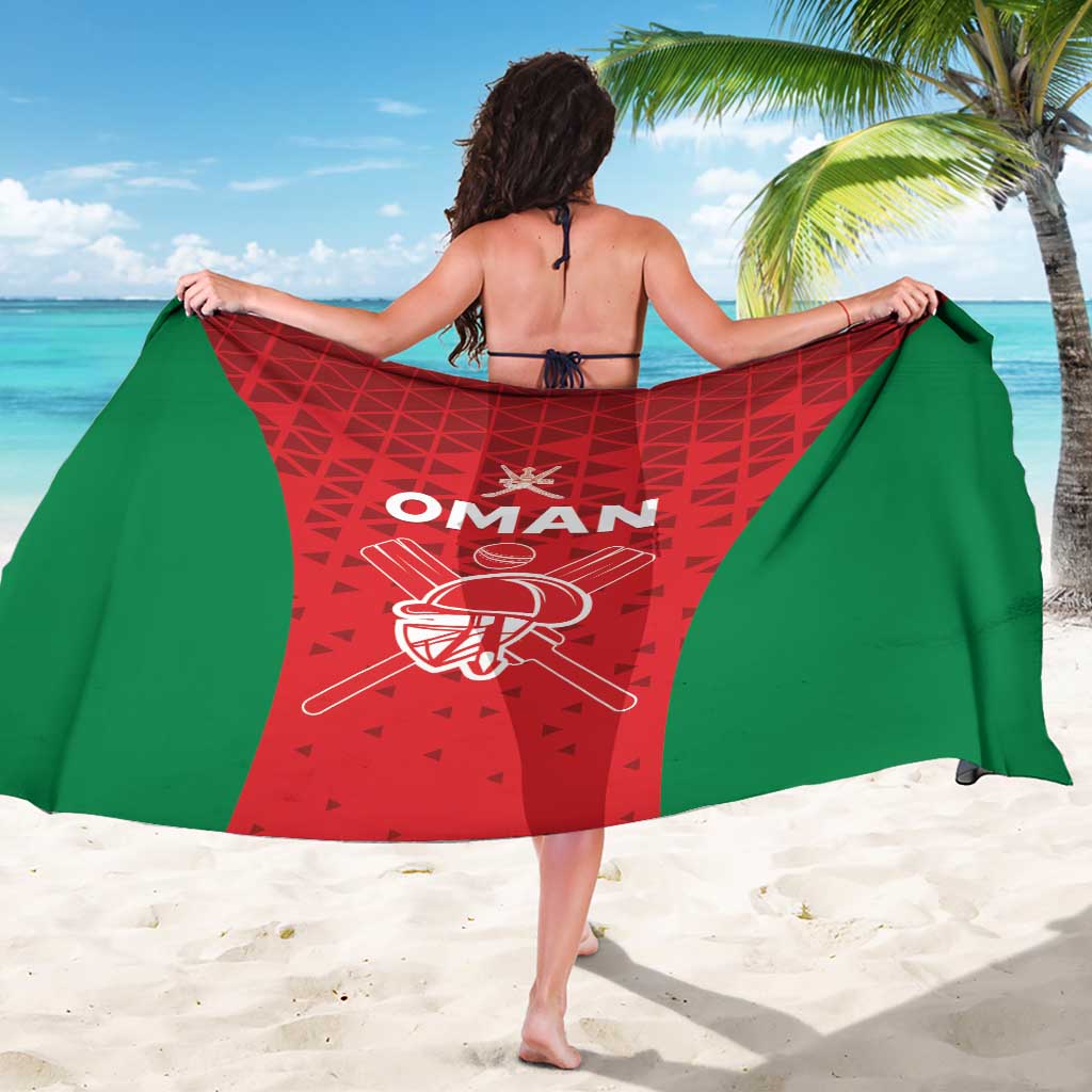 Cricket team sarong with red geometric panel, green borders, white Oman text and helmet