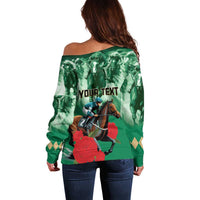 Green off-shoulder sweater with long sleeves and horse-racing graphic on back, with text