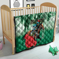 Green quilt on a toddler bed, featuring horse rider graphic with 'BELMONT' lettering