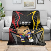 Black blanket on gray sofa, Germany DFB graphic with cartoon mascot and soccer ball