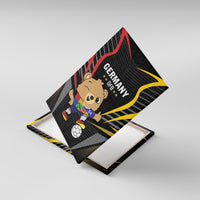 Black canvas print on wooden base, tilted view of Germany bear with soccer ball