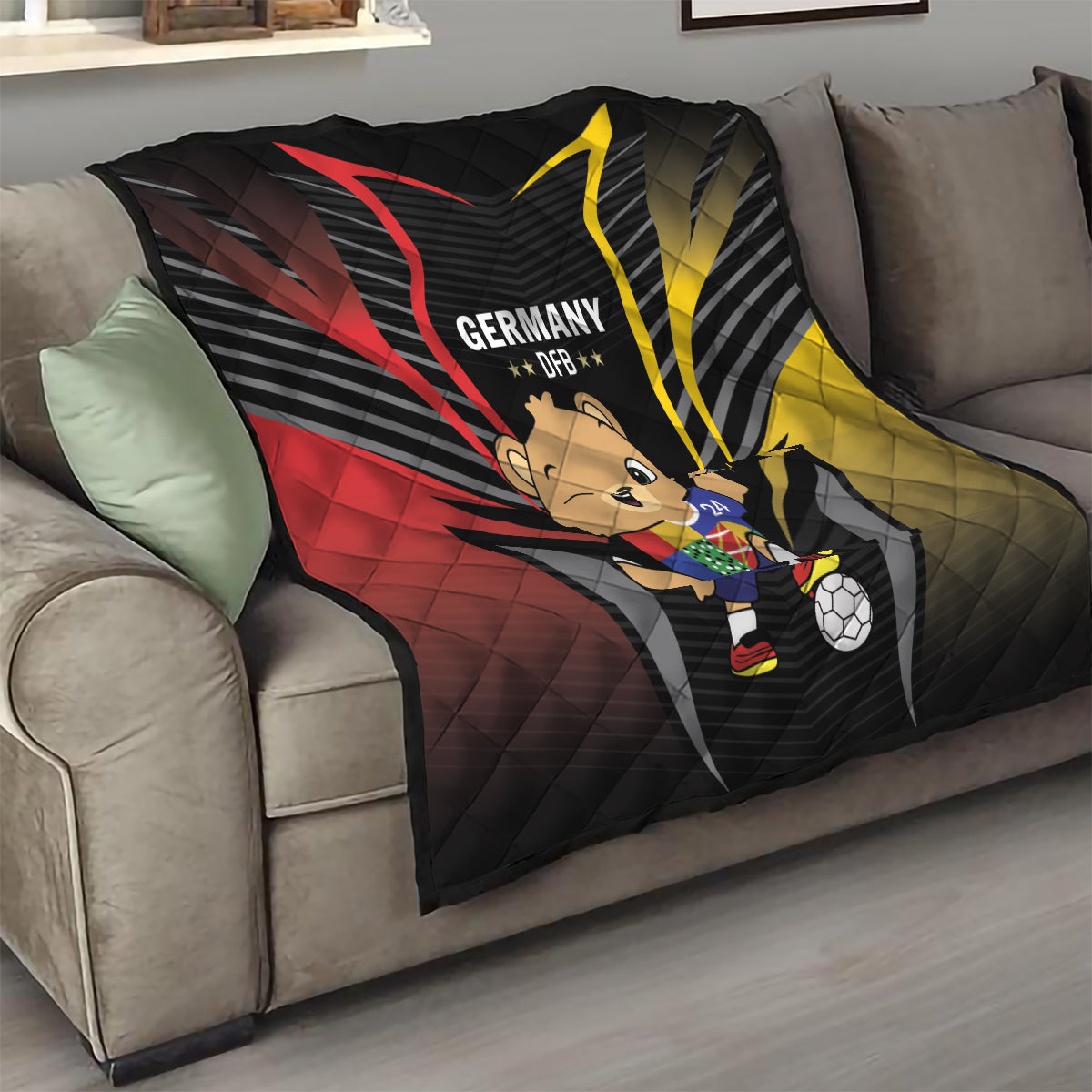 Black quilt on sofa showing Germany DFB emblem, bear mascot, soccer ball, red/yellow rays