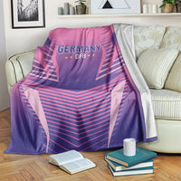 Pink and purple Germany DFB football blanket laid on a bed with logo centered on fabric.