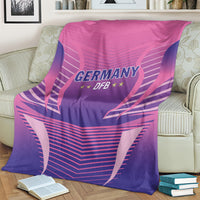 Pink and purple Germany DFB football blanket covering a sofa cushion, emblem visible.