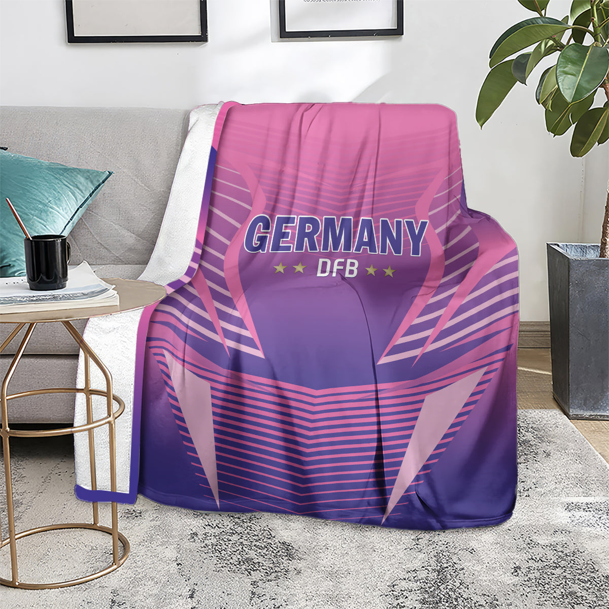 Pink and purple Germany DFB football blanket thrown over a couch with logo facing forward.