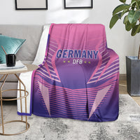Pink and purple Germany DFB football blanket thrown over a couch with logo facing forward.