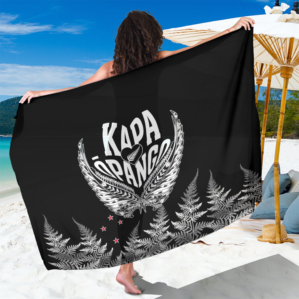 Black sarong with white winged emblem and fern-leaf print, draped