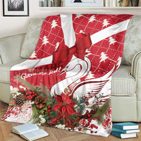 Red and white holiday blanket with bow and swan design, surrounded by winter greenery