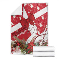Red and white Christmas blanket with bow and swan artwork, stacked with white folded layers