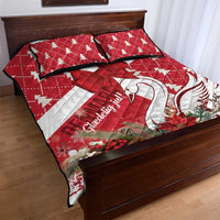 Red and white Christmas quilt bed set with swan motif and bow ribbon, on wooden bed