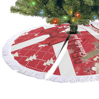 Red and white round Christmas tree skirt with red bow, swan scene, fringed trim