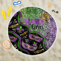 Round beach blanket with green purple and black Mardi Gras glitter print, white fringe edge