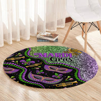 Round carpet with “MARDI Gras” lettering and purple-green decorative pattern on dark base.