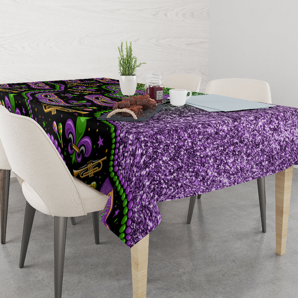 Mardi Gras tablecloth with purple glitter texture and green fleur-de-lis border, on dining table