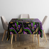 Mardi Gras tablecloth with black base, purple glitter section, and green fleur-de-lis pattern