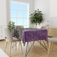 Mardi Gras tablecloth covering dining table; purple glitter surface with black and green design