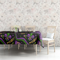 Mardi Gras tablecloth on buffet table; purple glitter right side with black and green fleur-de-lis