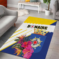 Floral tropical area rug with Bonaire wordmark and compass, blue and yellow striped border