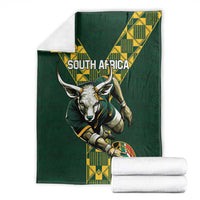 Green rugby blanket with South Africa lettering, ox head, and yellow geometric pattern