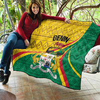 Benin quilt draped over a person’s lap; yellow and green flag layout with crest