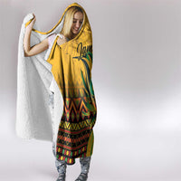 Yellow hooded blanket with white sherpa hood lining and colorful patterned hem