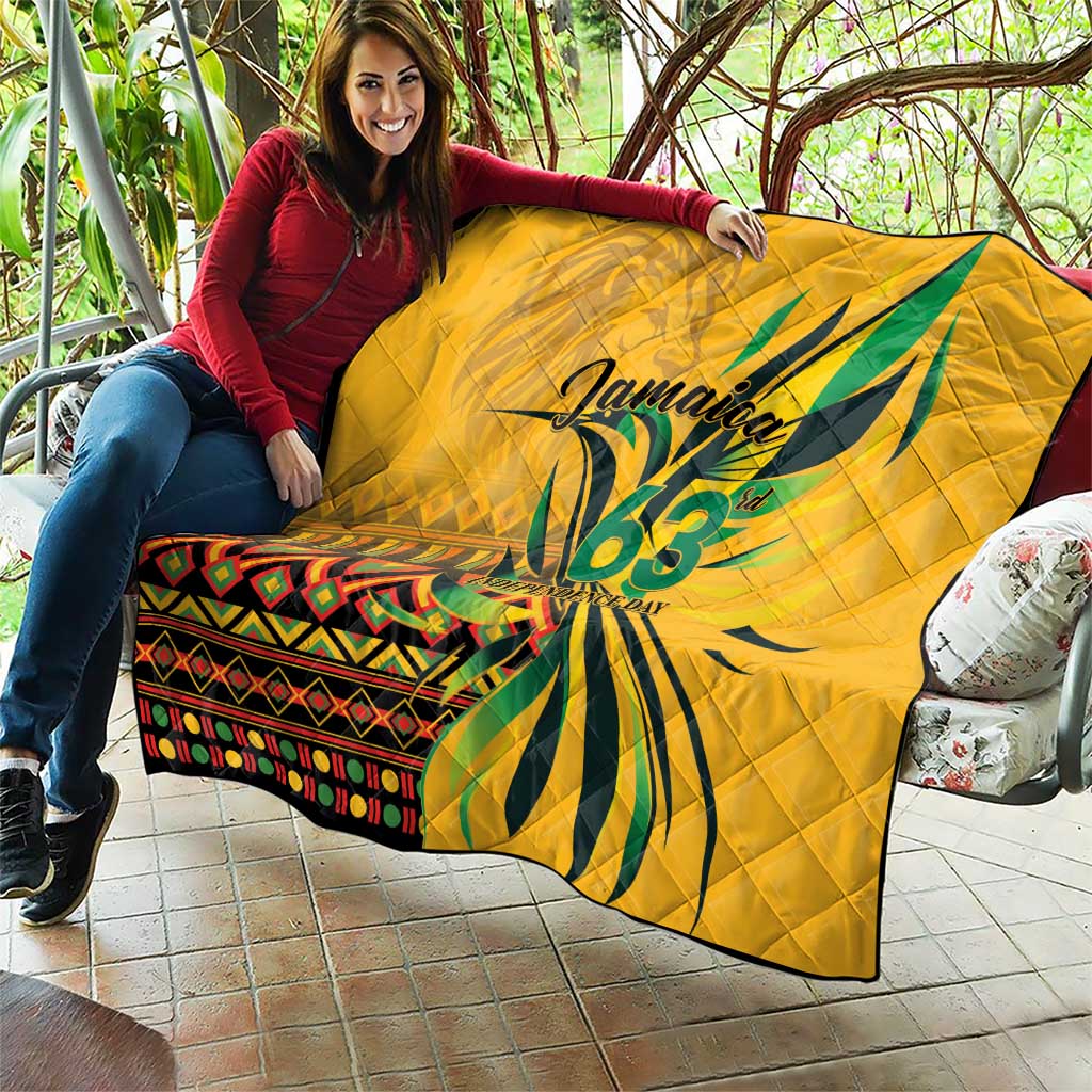 Yellow quilt held outdoors with green "Jamaica 63" and colorful stripe panel