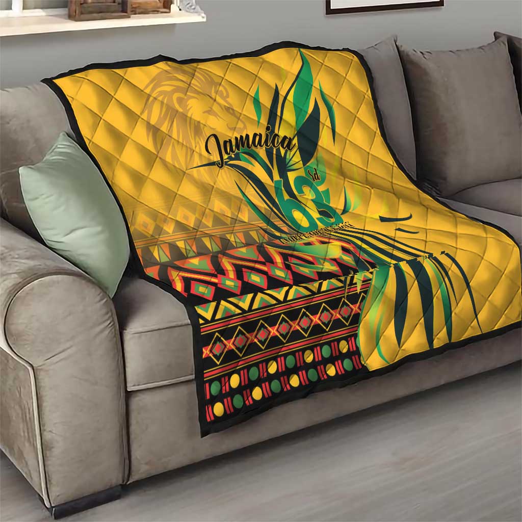 Yellow quilt draped on sofa with green "Jamaica 63" and patterned border