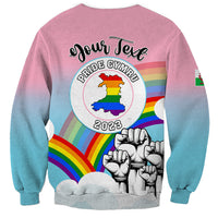 Unisex gradient pink-to-blue sweatshirt with circular Wales Pride emblem and fists graphic