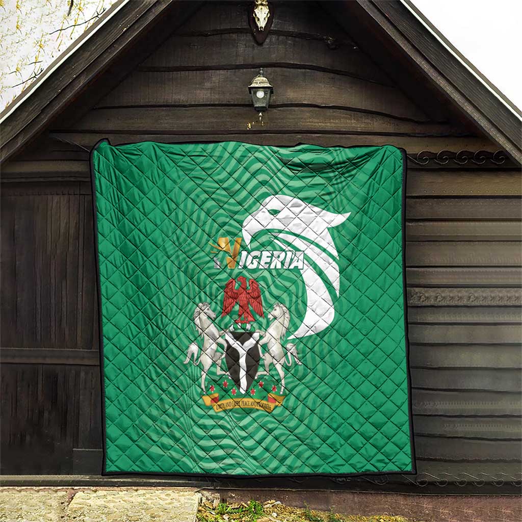 Green Nigeria quilt hanging in an open doorway, quilted diamonds and coat-of-arms graphic