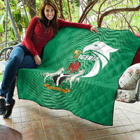 Green Nigeria quilt held by a person, quilted diamonds with emblem and flag-style print