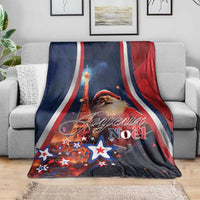 Blue Christmas blanket with Santa and Eiffel Tower artwork, stars, red white stripe edges on sofa
