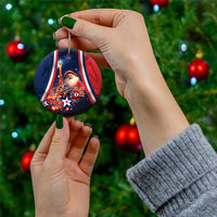 Blue round ceramic Christmas ornament with Santa and “Joyeux Noel”, held by hand