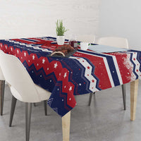 Christmas tablecloth draped over table edge in navy, red and white with stars and festive geometric pattern
