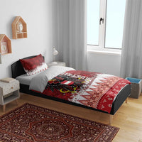 Red and white Christmas bedding set on bed with eagle crest, “Frohe Weihnachten,” and diamond border.