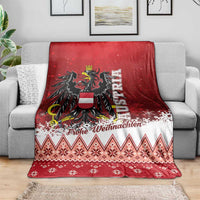 Red Christmas eagle throw blanket on gray sofa, with zigzag stripes and snowflake border