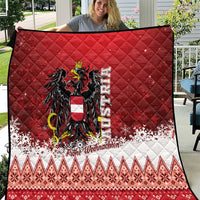 Red Christmas quilt with black and gold eagle crest, white snowy border and geometric patterns