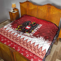 Red Christmas quilt on bed, eagle crest in center, white snowy border and patterned lower panel